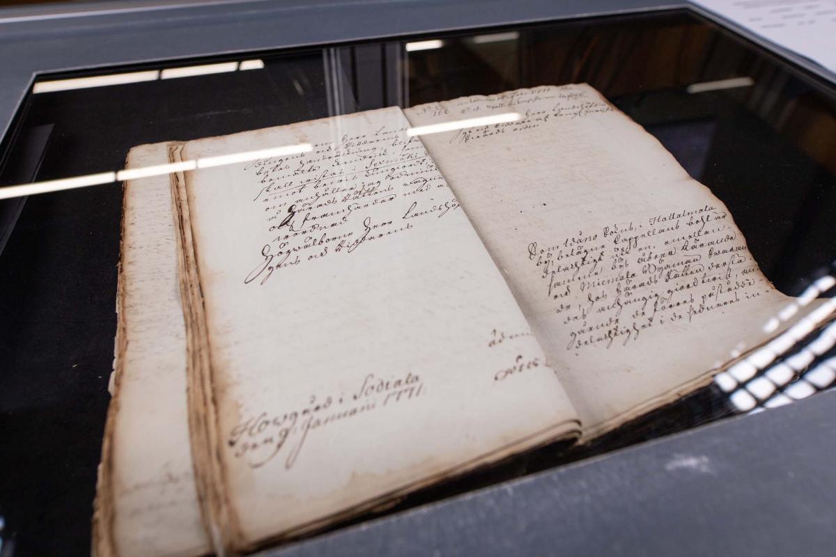 Kuvassa kuvauspöydällä vanha paperinen asiakirja.